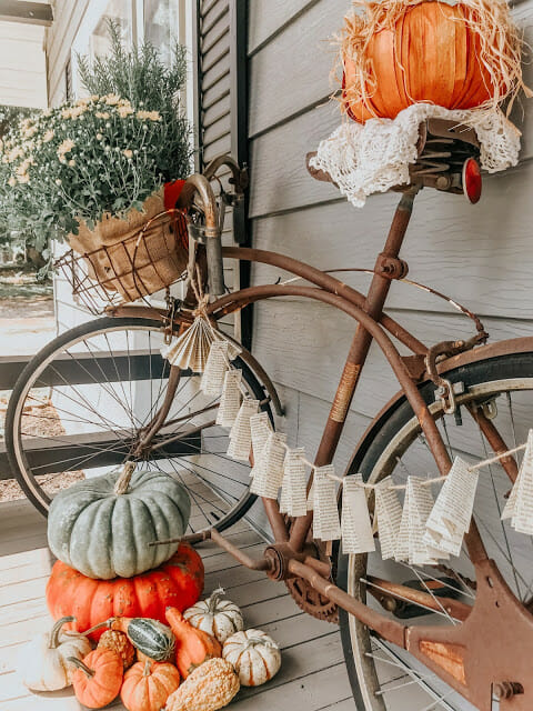 porch with bicycle, pumpkins and garland