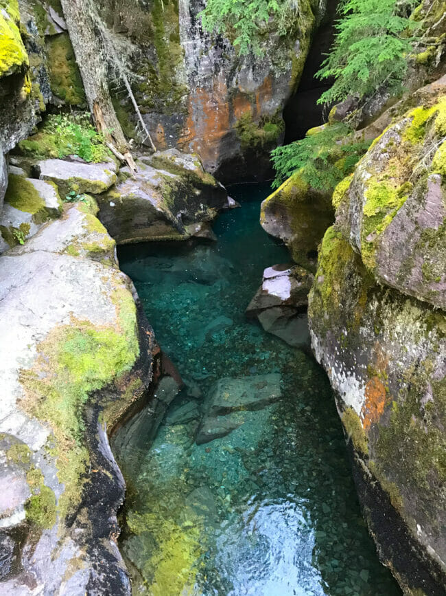 teal colored water in pond with rocks
