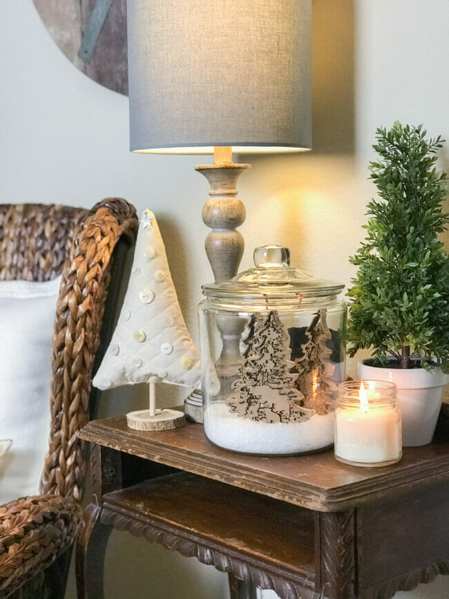 table with Christmas tree with buttons, greenery and Christmas jar and candle