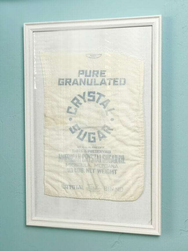 vintage sugar sack in white frame on blue wall