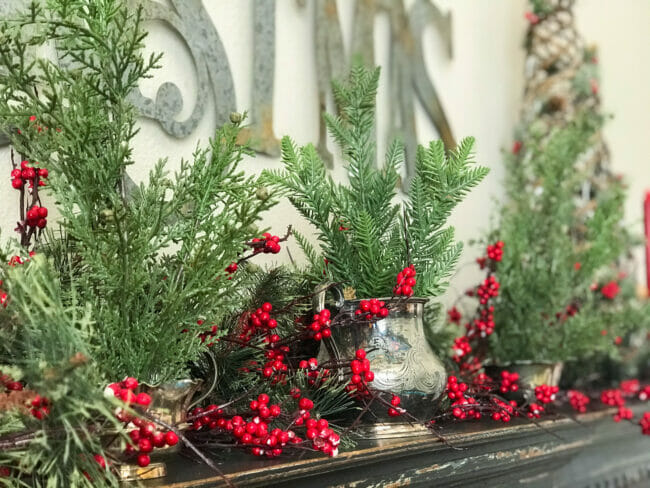 Christmas greenery with silver creamer and red berries