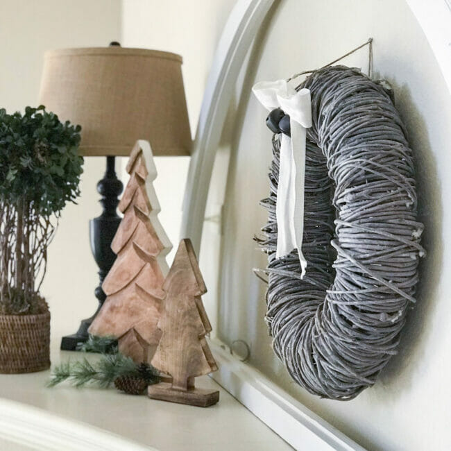 Gray wreath with wooden trees and black lamp