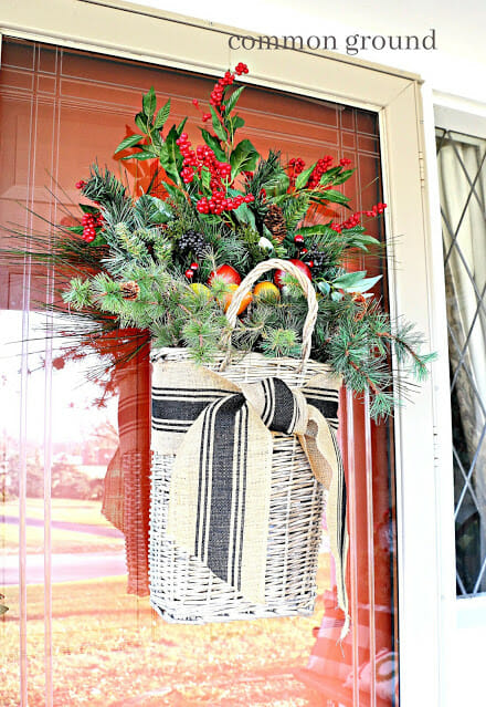 basket haning on door with greenery stems