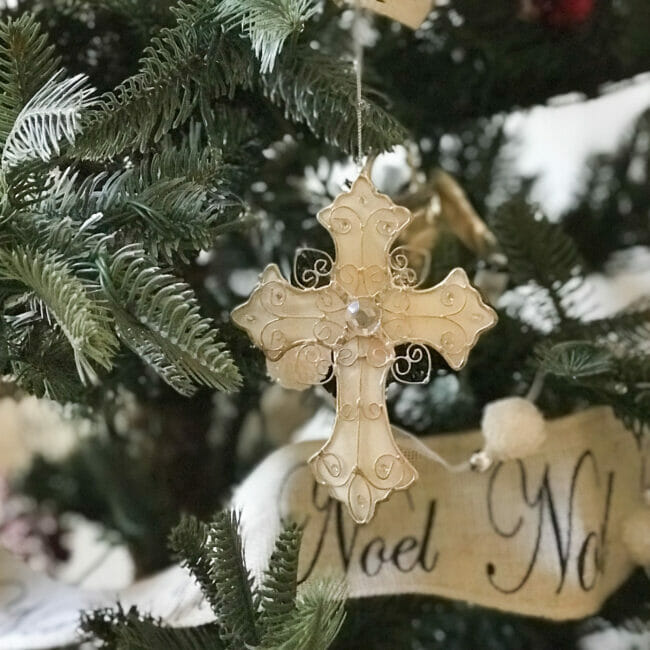 close up of white cross hanging on tree