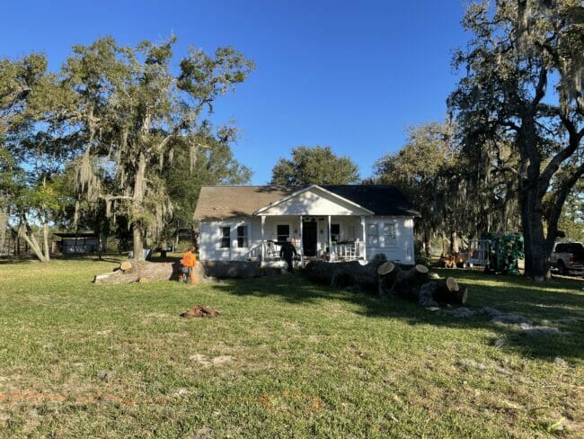 white farmhouse with trees around it