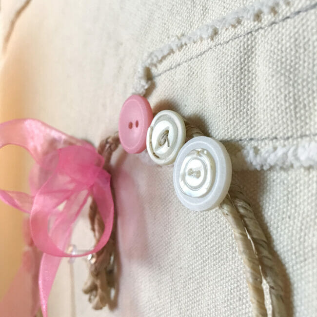 close up of wreath with pink and white buttons