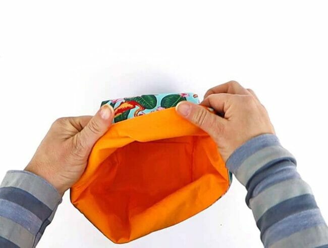 orange basket with hands folding top