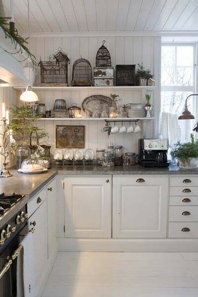 white kitchen with birdcages on open shelving