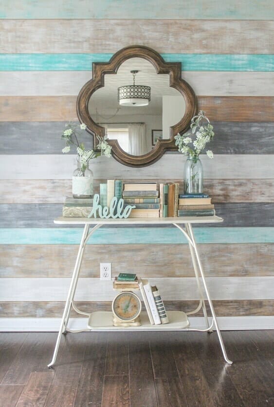 multi-colored wall with white entry table, mirror and coordinating blue and white books