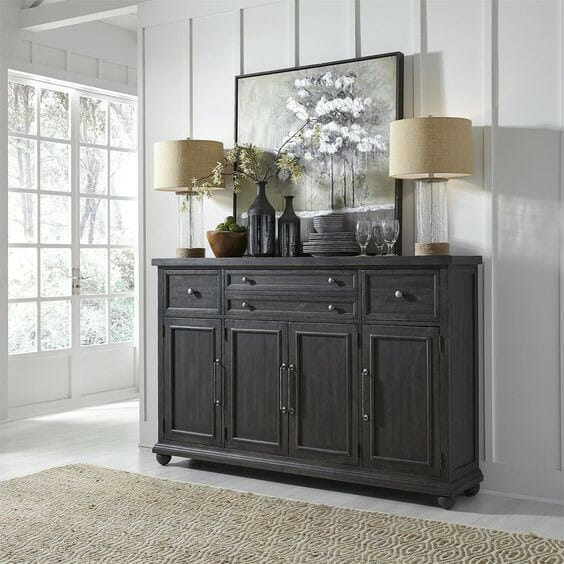 black console table with lamps and dishes