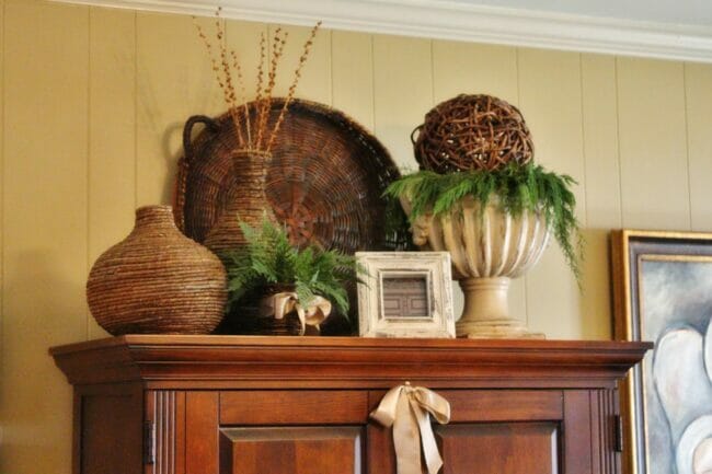 brown cabinet with basket and greenery