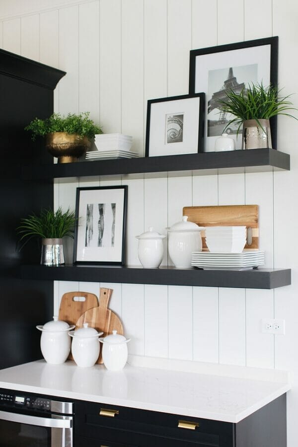 white shiplap wall with black shelves and decor