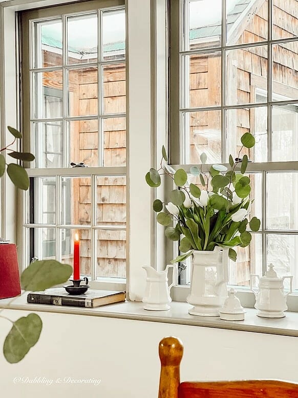 windowsill with white containers and red candle