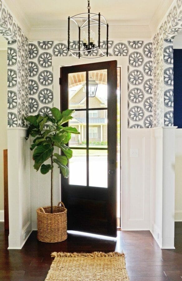 entry with black door, plant and wallpapered upper walls