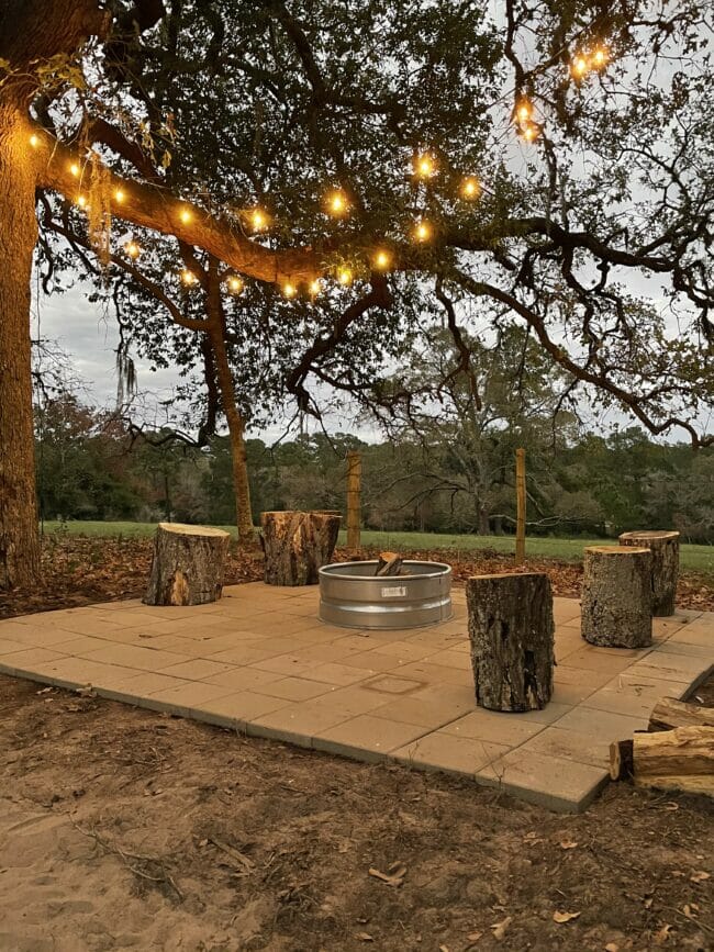 patio with fire pit and outdoor string lights hanging in trees