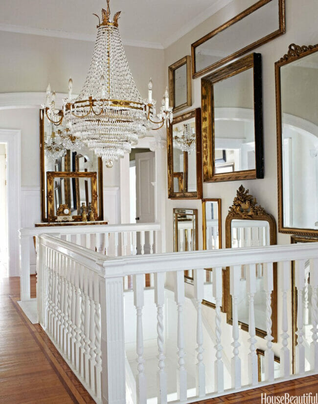 stairwell with gold mirrors on walls and chandy