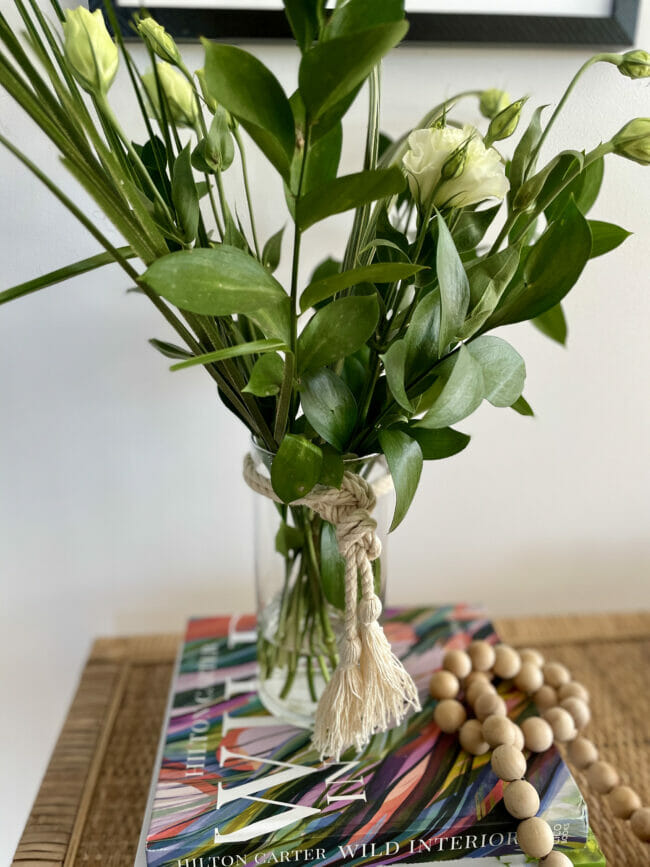 clear vase with green stems and rope tied around it