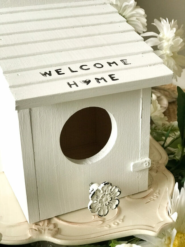 close up of white birdhouse with knob