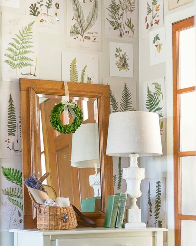 entry full of botanical prints on the walls and a wreath hanging on a mirror