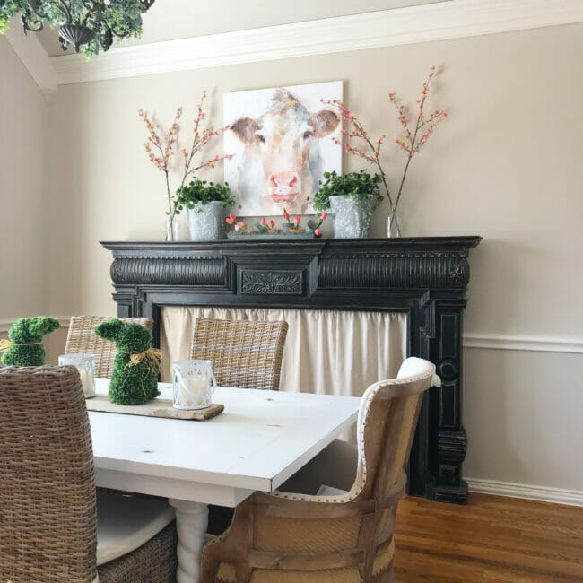 dining room with black mantel decorated with cow print and spring decor