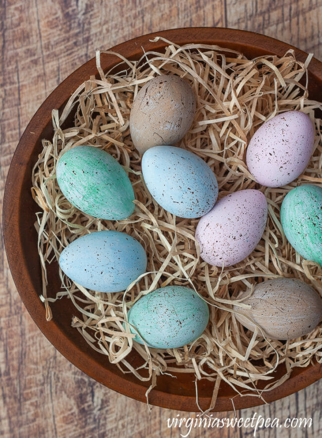 speckled easter eggs in bowl with raffia