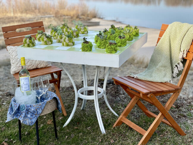 table with chairs in front of pond