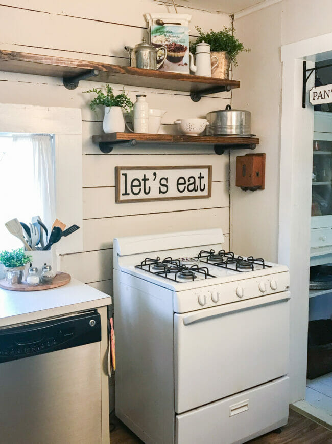 white stove, open shelving and let's sign