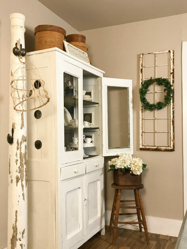 side view of hutch with column and wooden stool with flowers on top