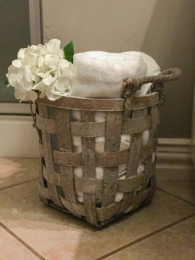 basket with white towels and flower