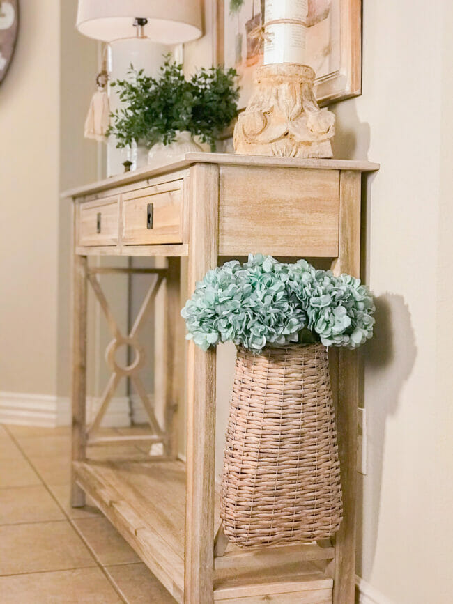 console table with hanging basket with teal flowers