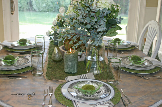tablescape with moss chargers, plates and candles
