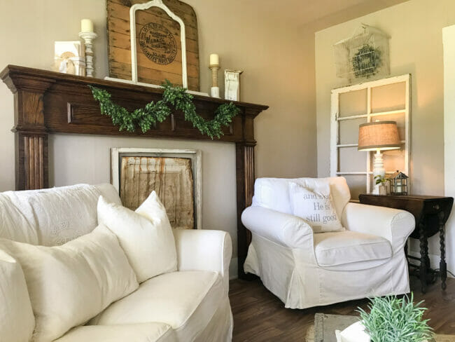 living room with mantel, white seating and vintage wall decor