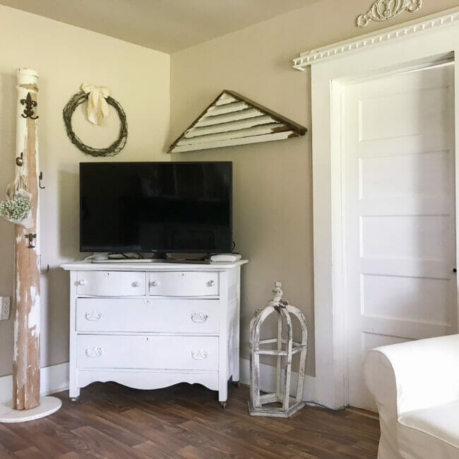 TV on old dresser with column and wreath