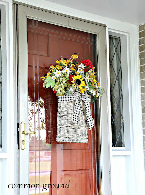 white wicker basket with flowers hanging on front door