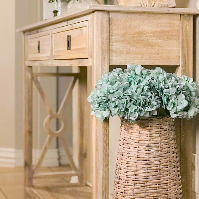 side of cnsole table with basket of blue hydrangeas