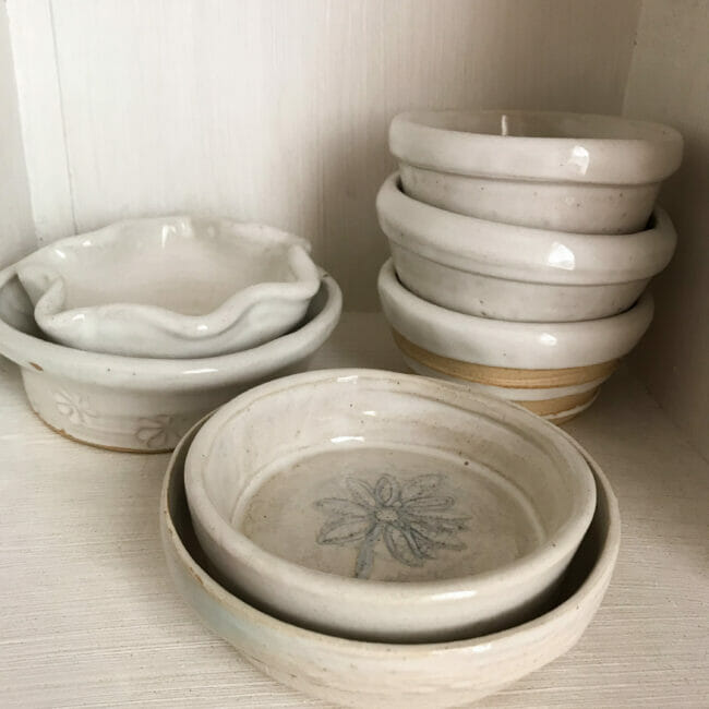 Stacked handmade pottery bowls inside cubby 