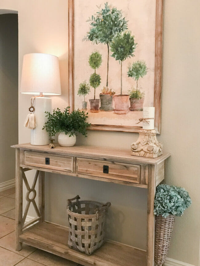Summer entryway table with lamp, plant and canvas painting of topiaries