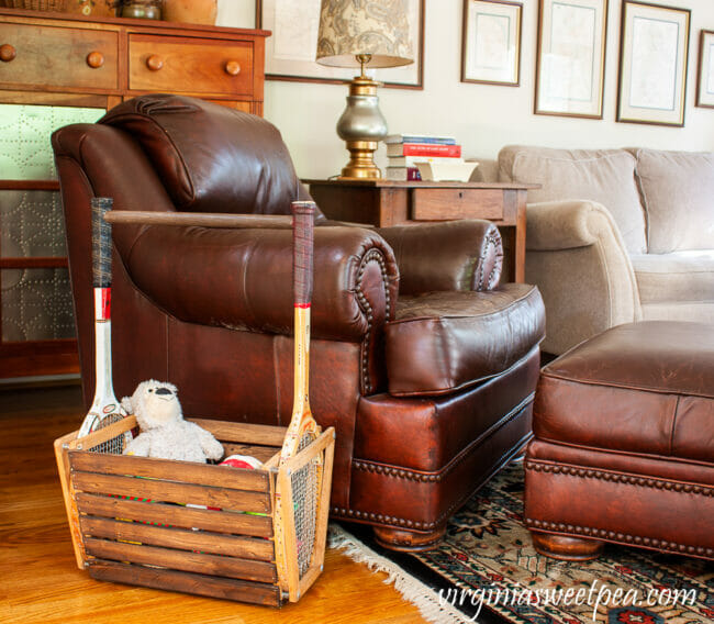 leather chair with magazine rack made of tennis rackets next to it