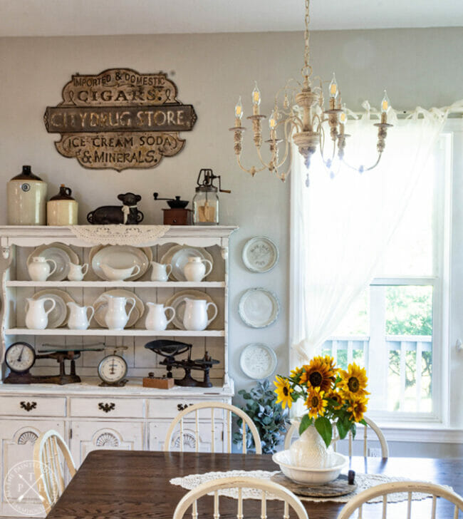 white dining hutch with sunflowers on table