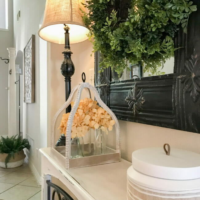 white lantern on table with gold hydrangeas