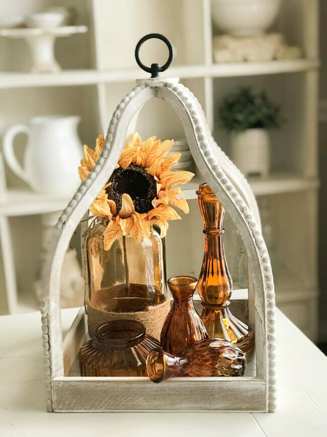 white lantern with fall decor and amber glassware
