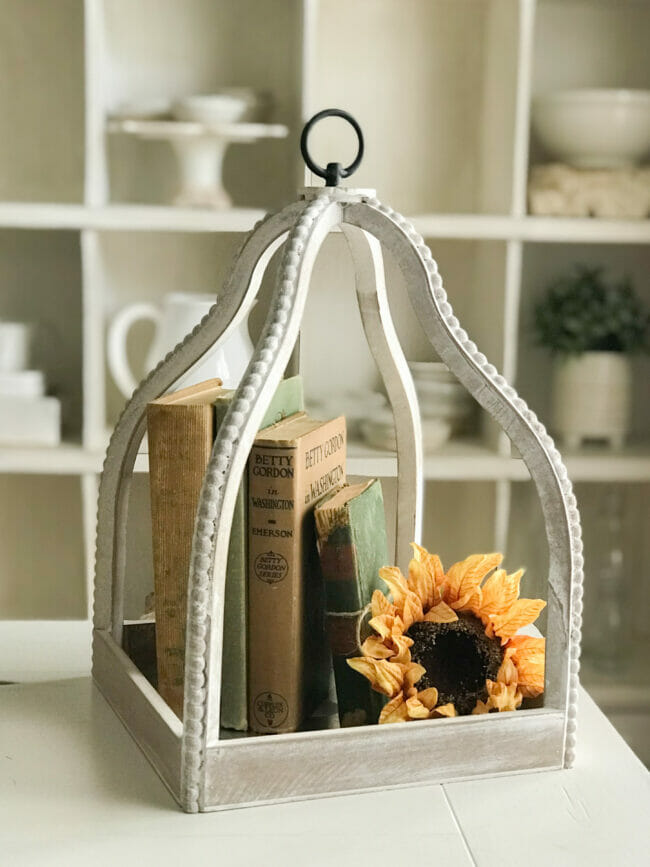 white lantern with late summer sunflower and vintage books