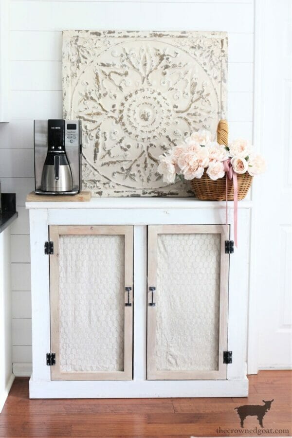 cabinet with coffee maker and basket of flowers