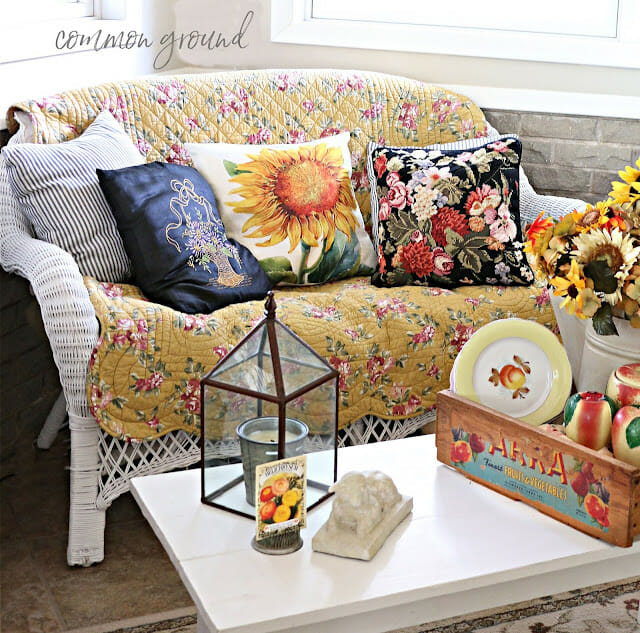 wicker settee with sunflower pillows and quilt
