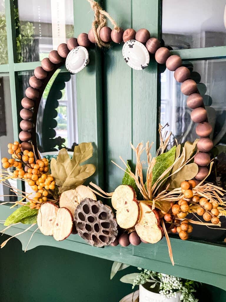 wood bead wreath hanging on green door