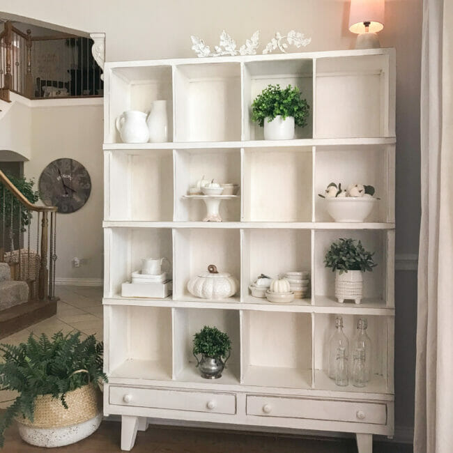 white cubby shelf with white fall decor