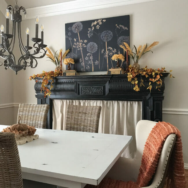 fall dining room with black mantel and large floral print