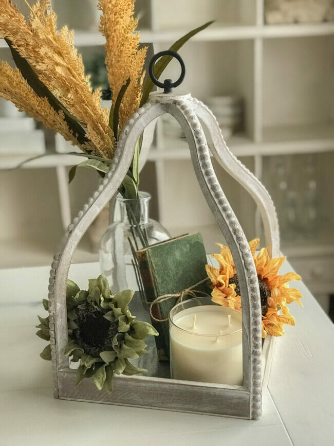 lantern with wheat stems, sunflowers and book inside