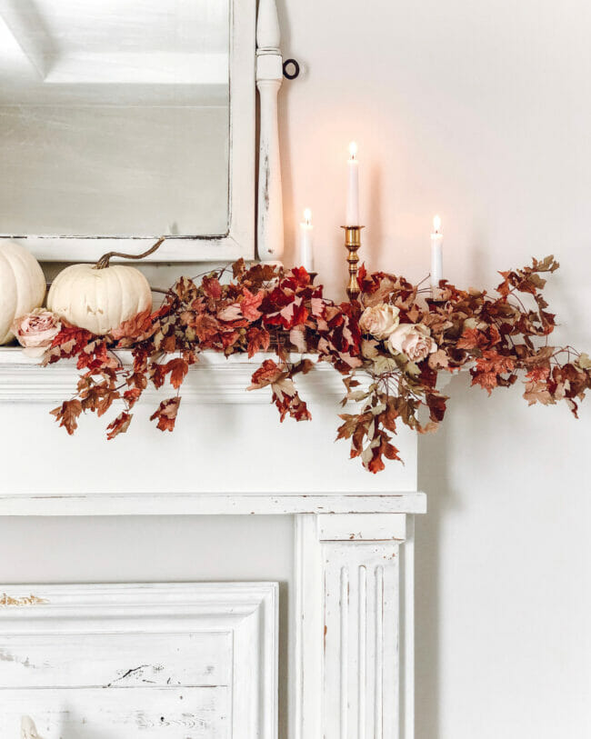 white mantel with mirror, candles and fall stems in reds