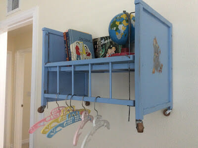 blue baby doll bed hanging on wall